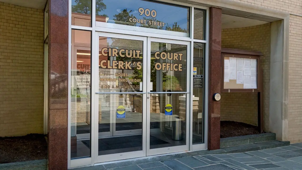 Glass entrance doors to the Circuit Clerk's Court Office at 900 Court Street with official notices posted in a display case beside the entrance.